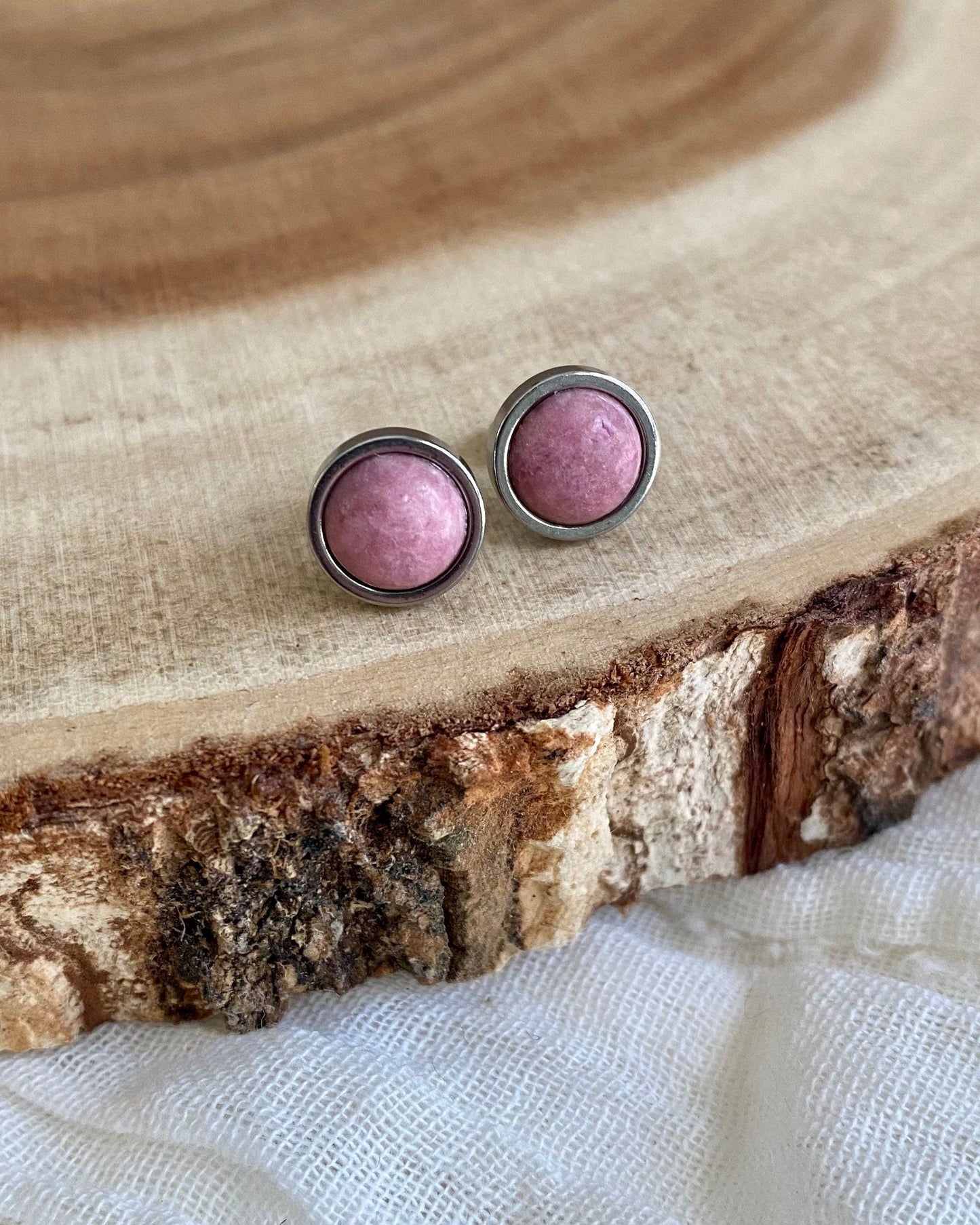 Pink stud earrings on a wooden surface