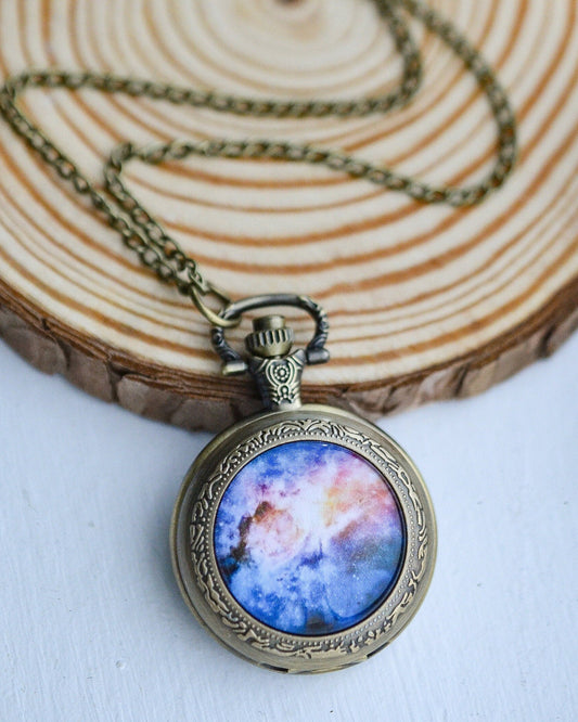 Necklace with a pendant featuring a colorful galaxy design on a wooden surface.