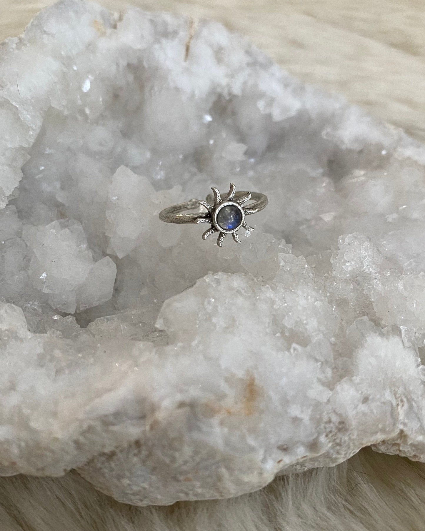 Silver ring with a blue tint gemstone on a white crystal formation
