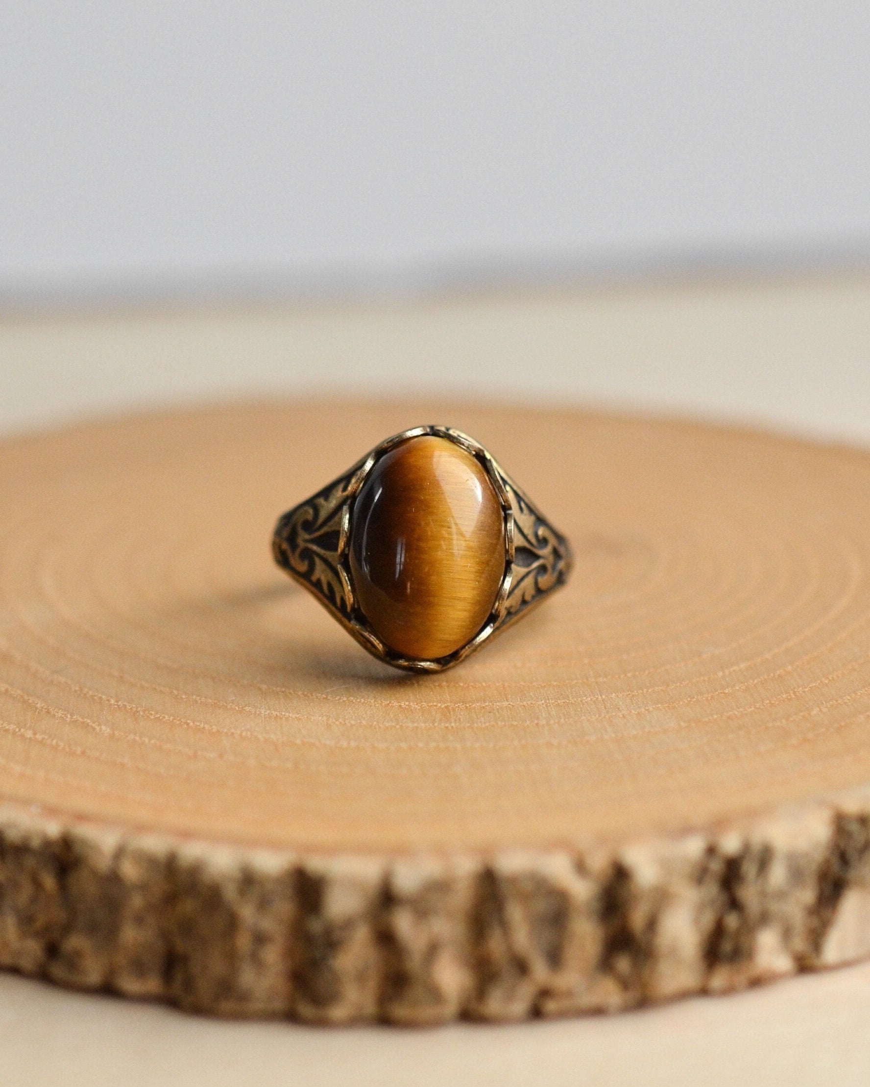 Ring with a tiger's eye stone on a wooden surface