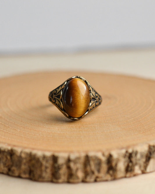 Ring with a tiger's eye stone on a wooden surface