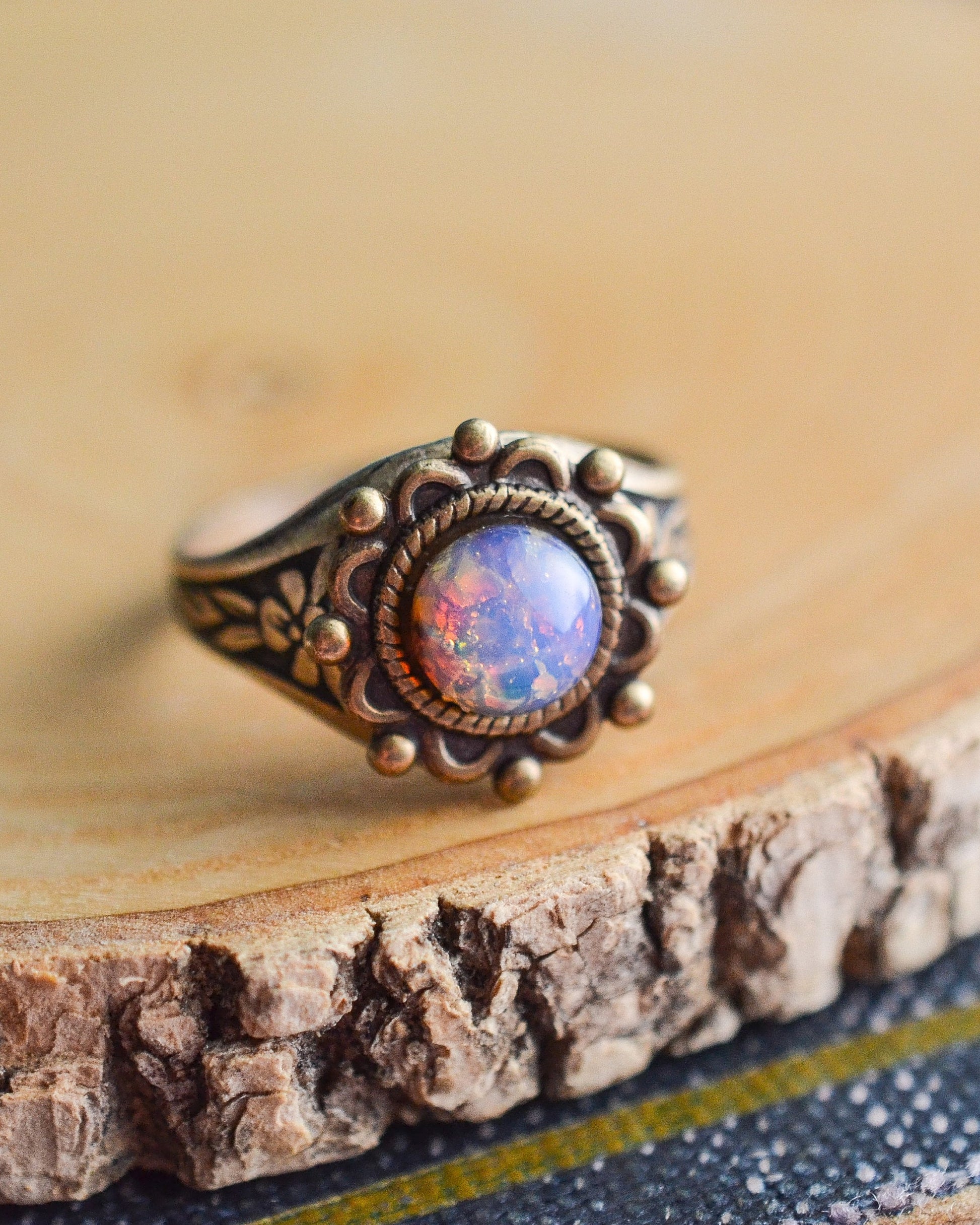 Ring with a colorful stone on a wooden surface