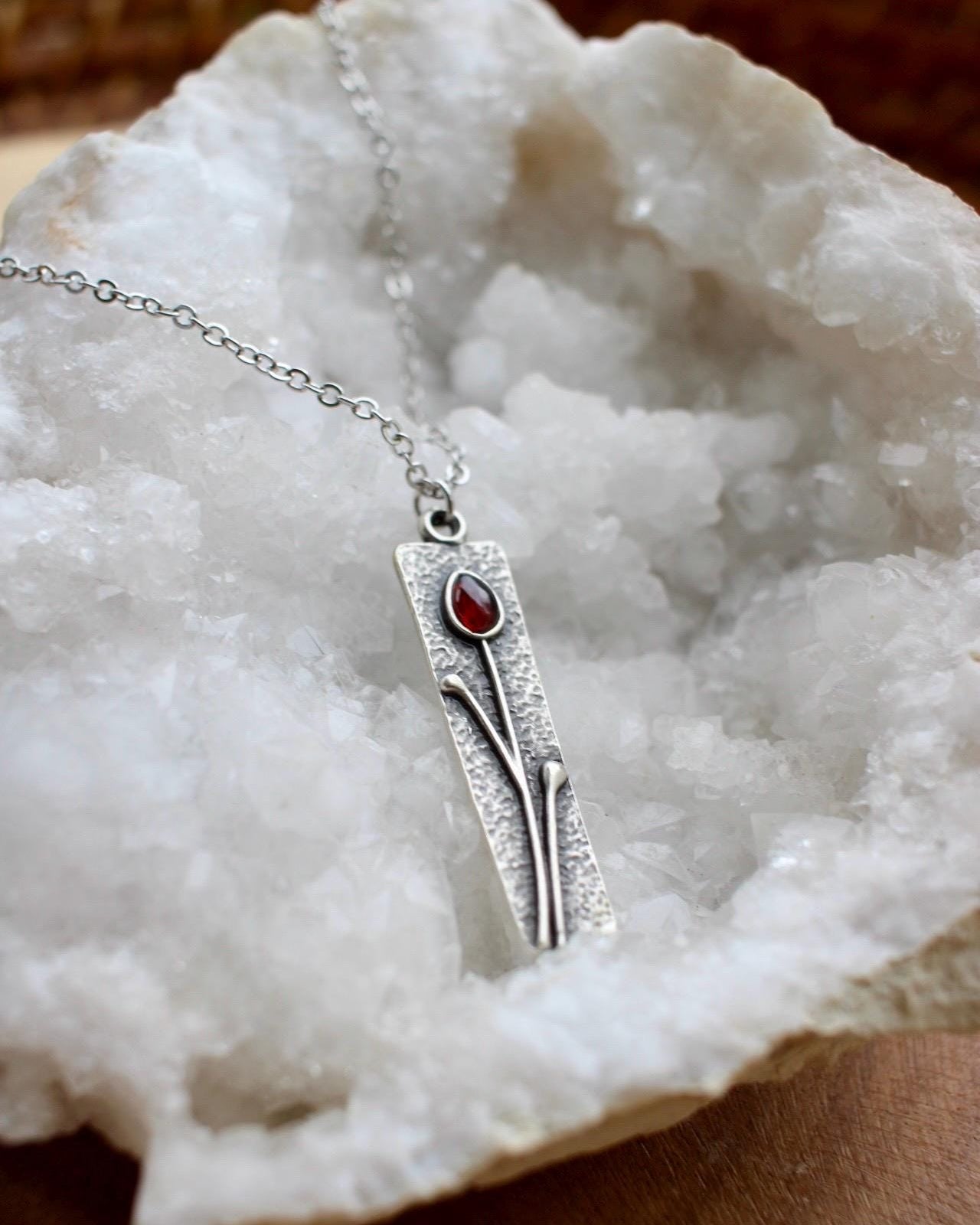 Silver necklace with a pendant on a white stone surface
