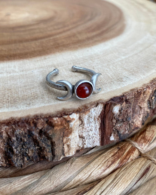 Silver triple moon ring with red orange stone in the middle