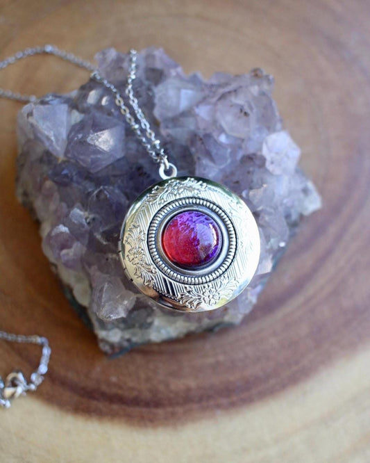 Necklace with a red stone set in a locket pendant on a wooden surface