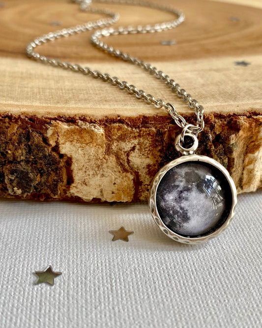 Necklace with a moon-phase pendant on a wooden surface