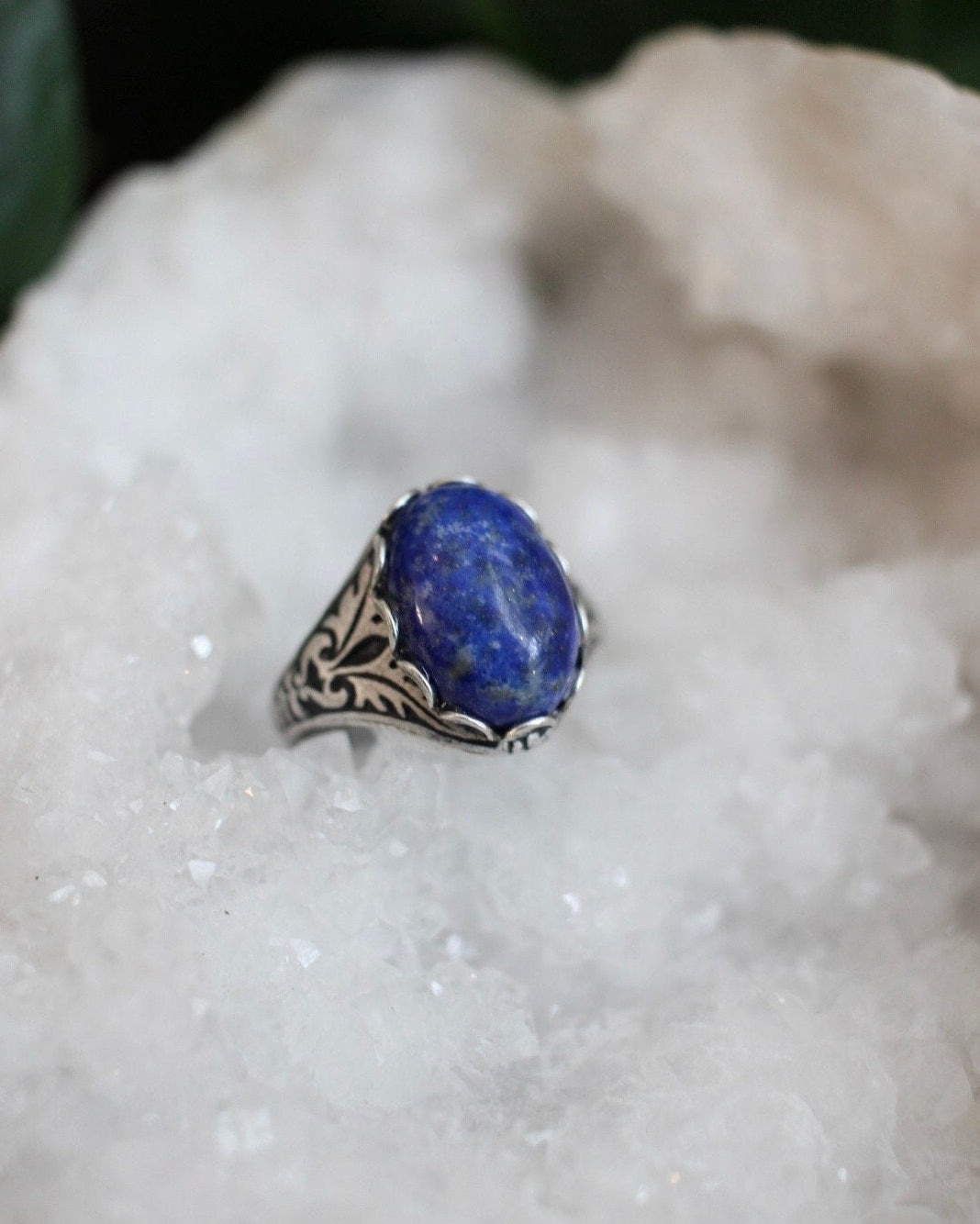 Silver ring with a blue stone on a white crystal surface