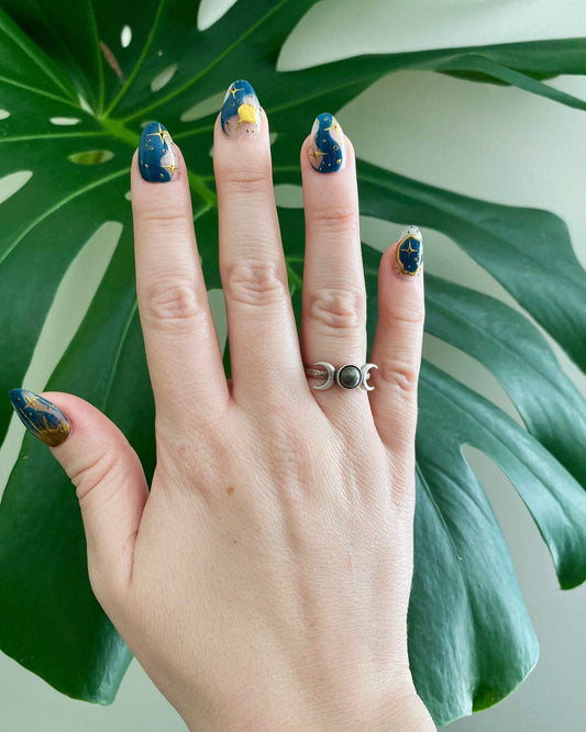 Pyrite triple moon ring on a hand with galaxy nails