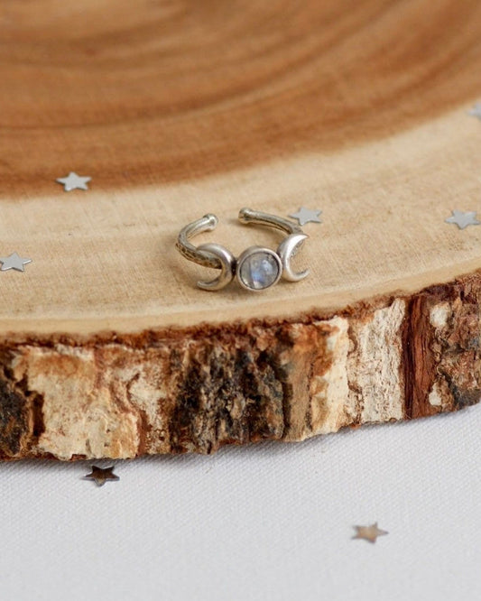 Silver ring with a clear blue stone on a wooden surface
