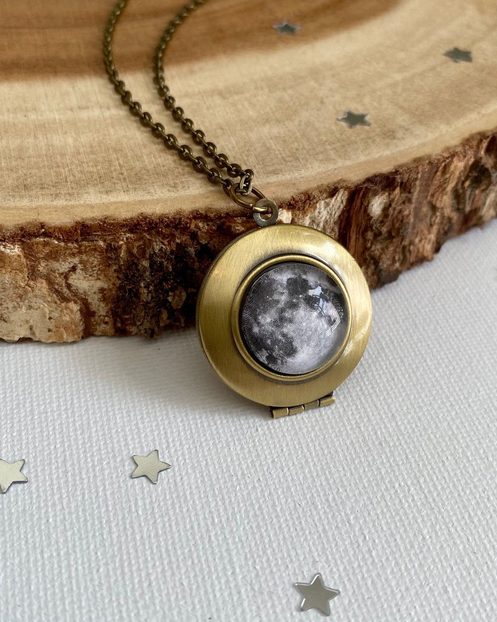 Brass necklace with full moon locket pendant on wooden surface
