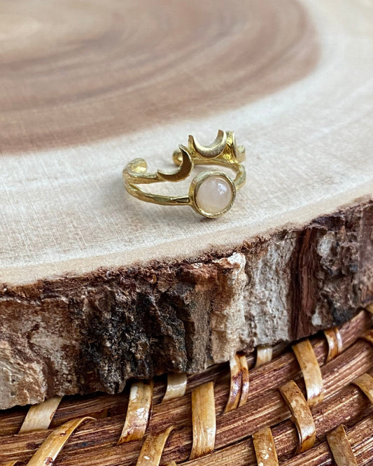 Gold ring with a rose quartz gemstone on a wooden surface