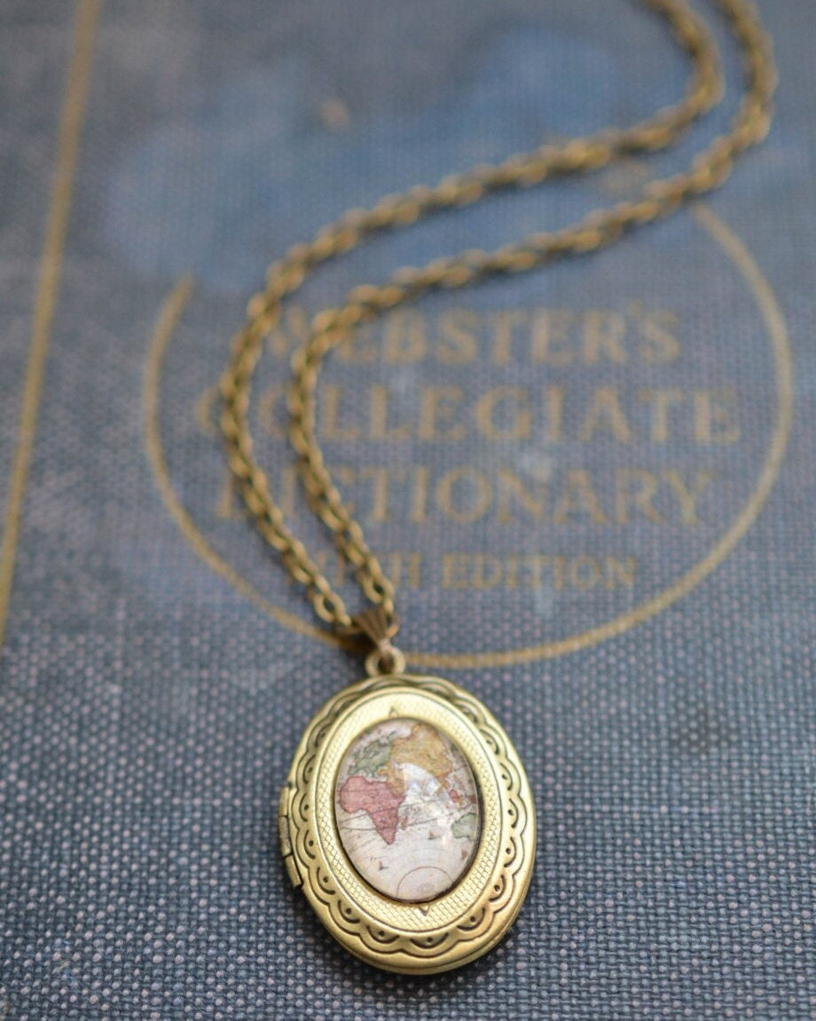 Bronze locket necklace on a textured surface with text in the background