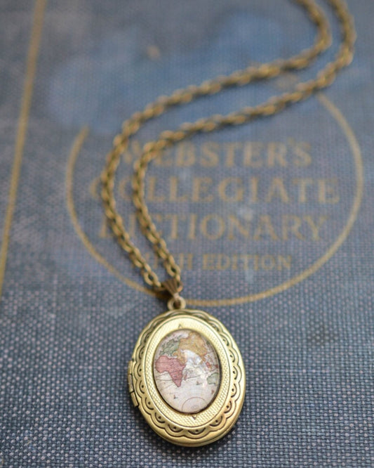 Bronze locket necklace on a textured surface with text in the background