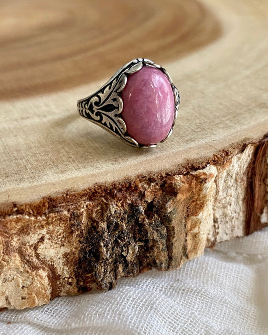 Pink stone ring on a wooden slab