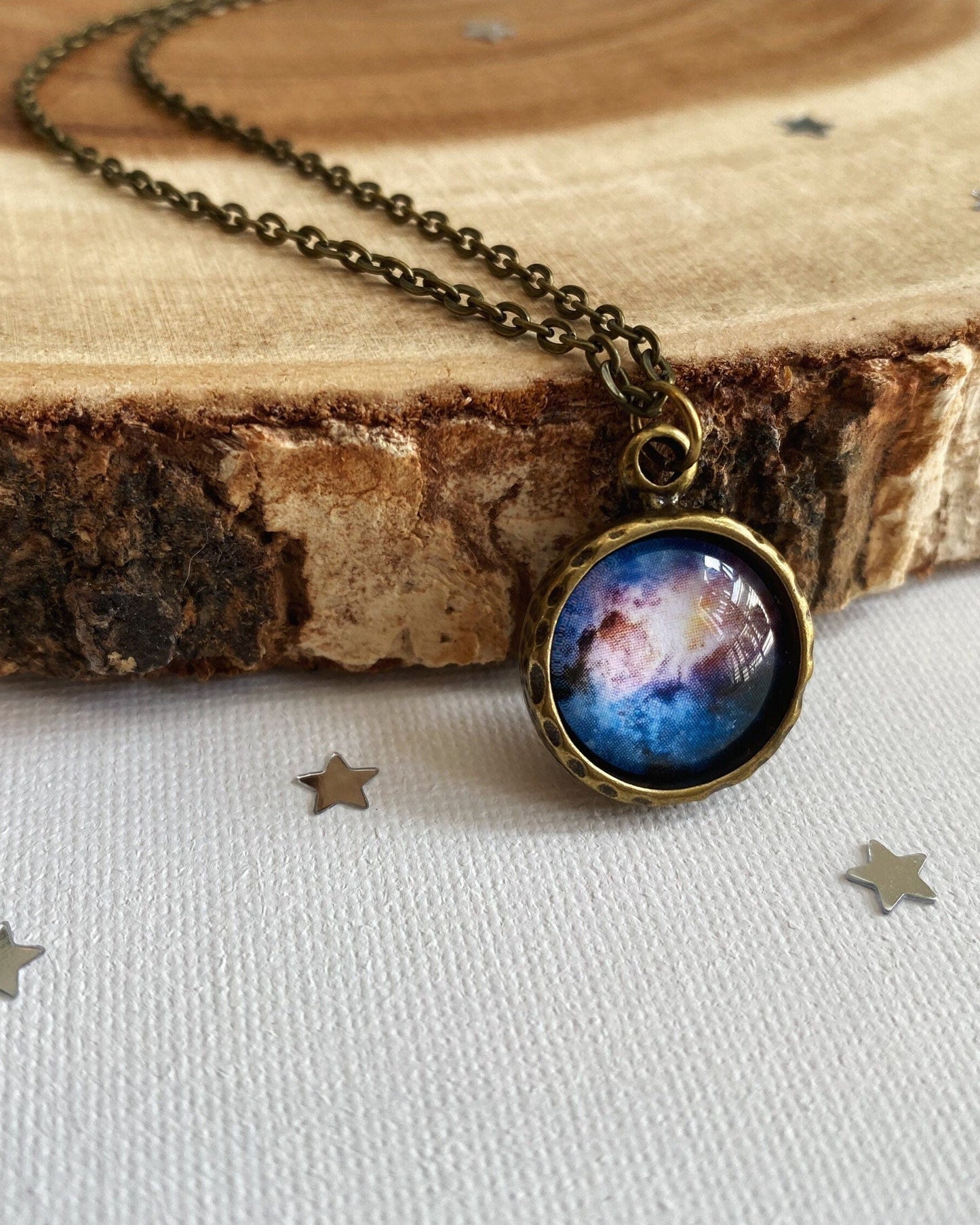 Necklace with a space-themed pendant on a wooden surface