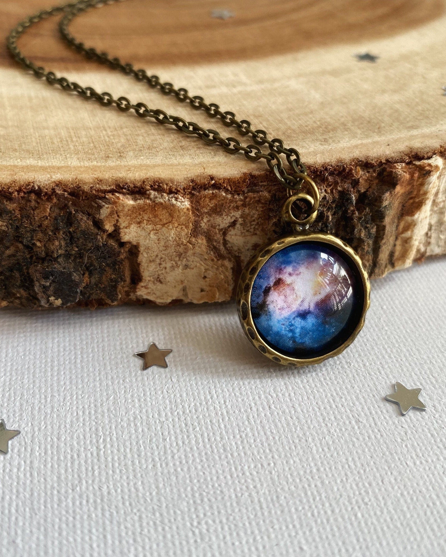 Necklace with a space-themed pendant on a wooden surface
