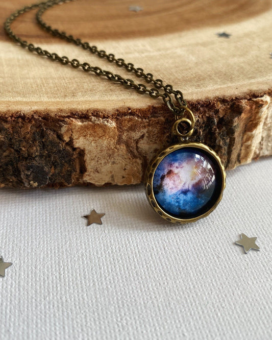 Necklace with a space-themed pendant on a wooden surface